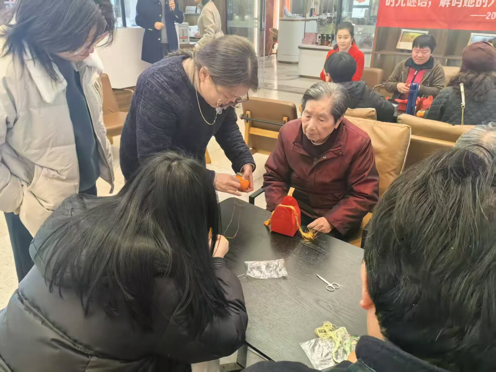 1.汪老师帮助游客完成刺绣.jpg